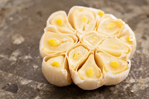 Roasted garlic head on baking sheet — Stockfoto