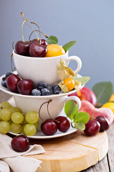 Frutas de hueso fresco y cerezas en tazas —  Fotos de Stock