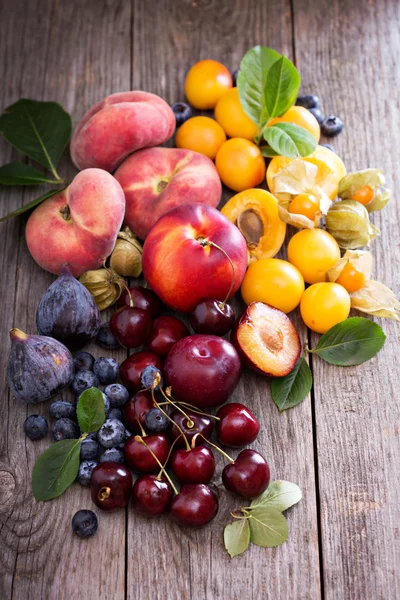 Färska stenfrukter på träbord — Stockfoto