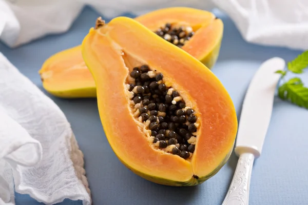 Cortar la papaya en una mesa azul —  Fotos de Stock