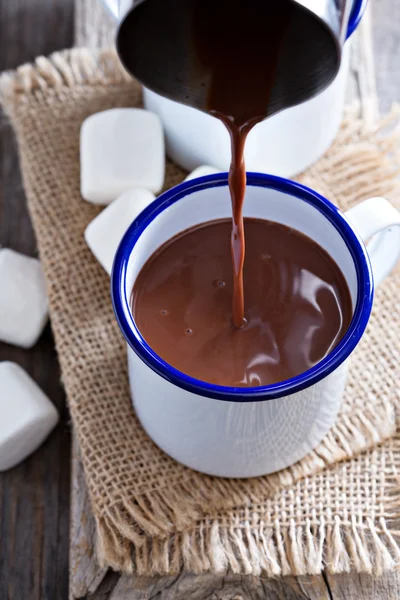 Chocolate quente derramando em uma xícara — Fotografia de Stock