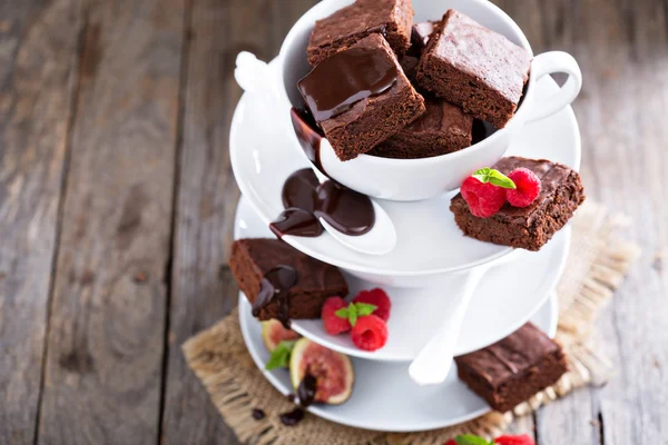 Brownies dans des tasses à café empilées avec sauce au chocolat Image En Vente