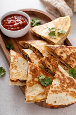 Ekşi krema ve salsa soslu hindi ve cheddar quesadillas.