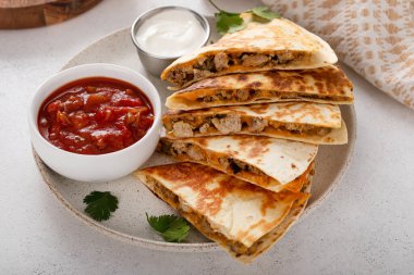 Ekşi krema ve salsa soslu hindi ve cheddar quesadillas.