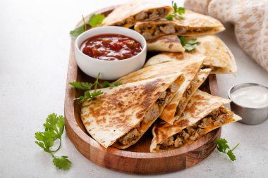 Ekşi krema ve salsa soslu hindi ve cheddar quesadillas.