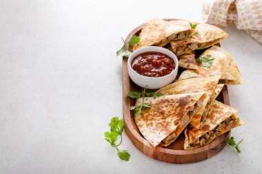 Ekşi krema ve salsa soslu hindi ve cheddar quesadillas.
