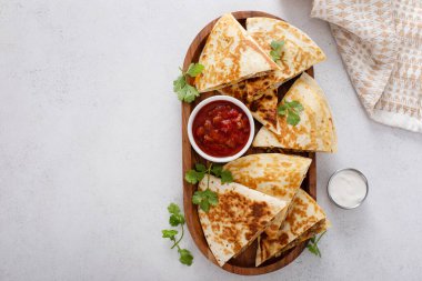 Ekşi krema ve salsa soslu hindi ve cheddar quesadillas.