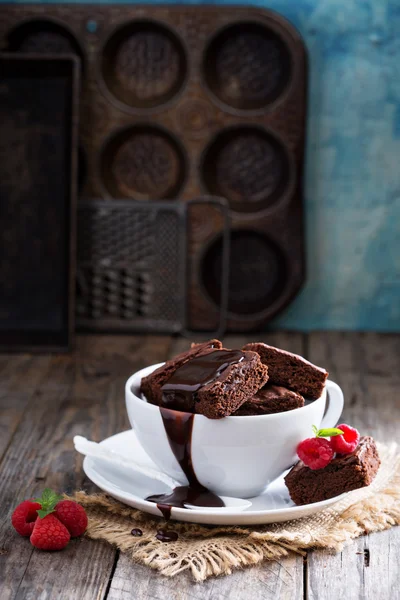 Brownies dans des tasses à café empilées avec sauce au chocolat Photos De Stock Libres De Droits