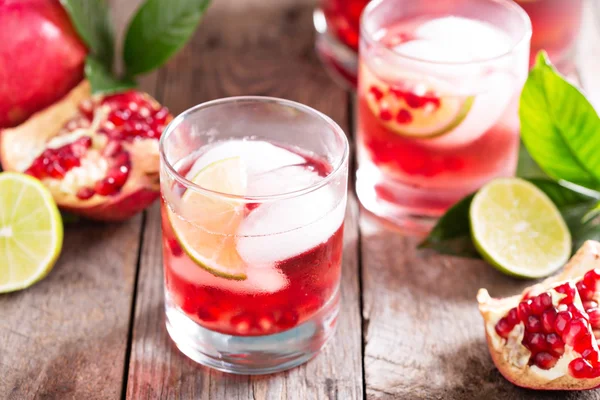 Pomegranate cocktail with lime slices — Stock Photo, Image