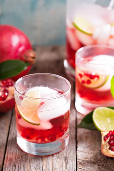 Pomegranate cocktail with lime slices — Stock Photo, Image
