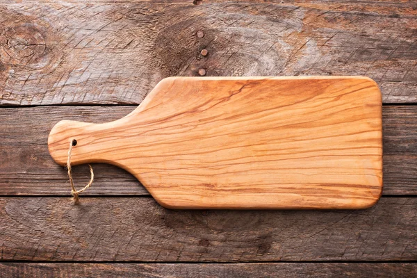 Fundo rústico de madeira com uma placa de corte — Fotografia de Stock