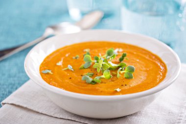 Curried carrot soup with cream and herbs clipart
