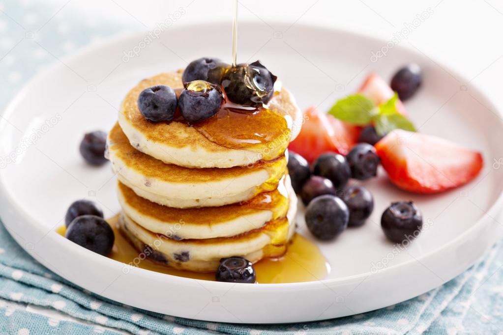 Stack of small pancakes with fresh berries