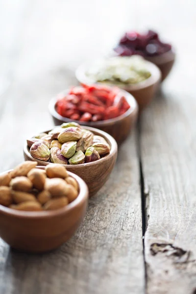 Variety of nuts and dried fruits in small bowls — Stock Photo, Image