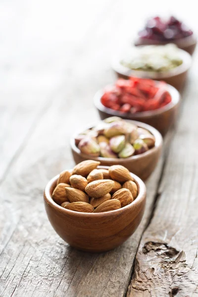 Variety of nuts and dried fruits in small bowls — Stock Photo, Image
