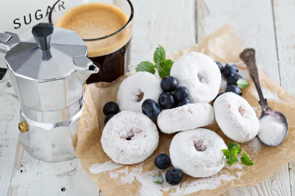Poedersuiker donuts op perkament — Stockfoto
