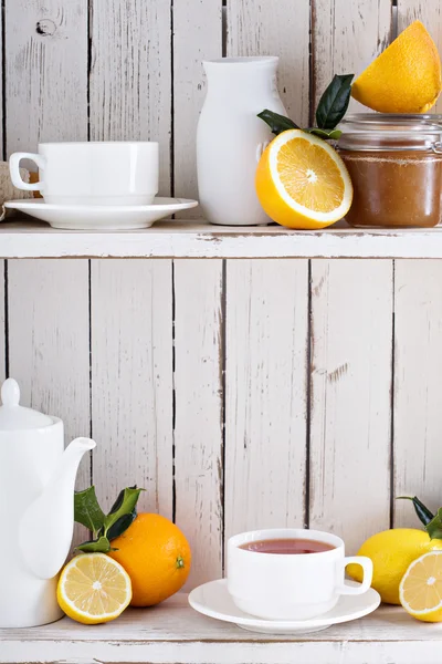 Tea with citrus fruits on the shelf — Stock Photo, Image