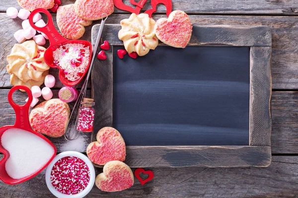 Sevgililer günü kurabiyeleri yazı tahtası çevresinde — Stok fotoğraf