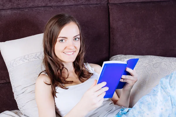 Kobieta, leżąc w łóżku czytając książkę — Zdjęcie stockowe