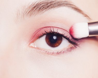 Eye makeup. Woman applying pink eyeshadow powder clipart