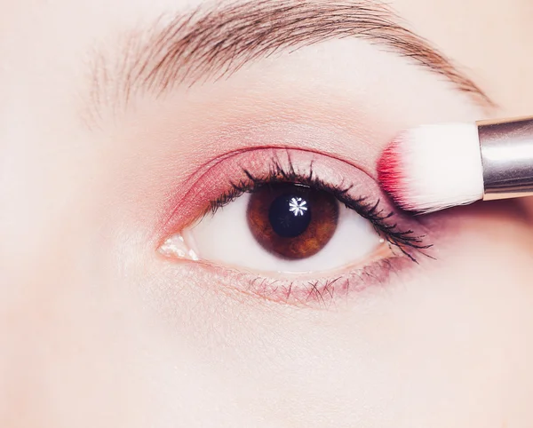 Trucco agli occhi. Donna che applica polvere di ombretto rosa — Foto Stock