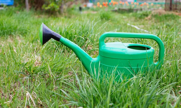 新しい緑の水まき缶を踏んで草 — ストック写真