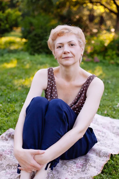 Portrait of middle aged woman smiling in the park — Stock Photo, Image