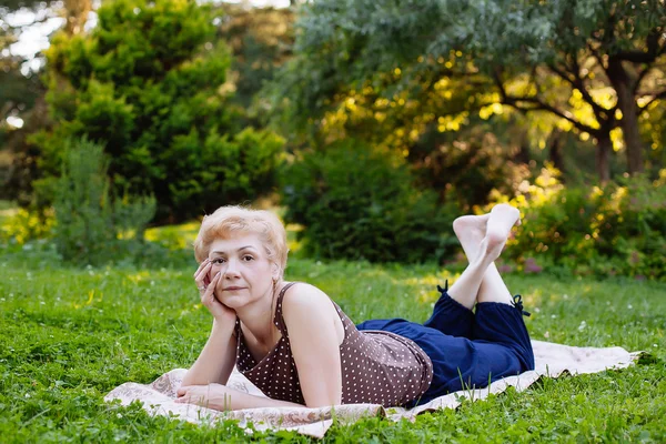 Portrét středního věku ženy usmívající se v parku — Stock fotografie