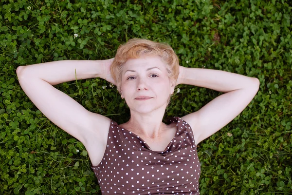 Portrait of middle aged woman smiling in the park — Stock Photo, Image