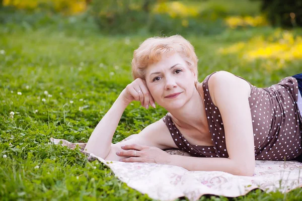 Portret Kobieta w średnim wieku uśmiechający się w parku — Zdjęcie stockowe