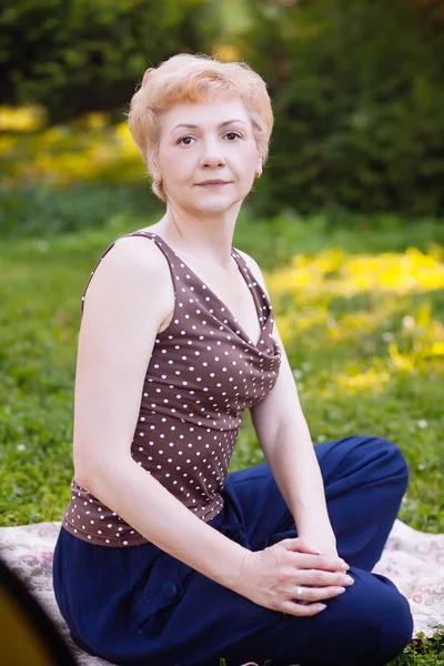 Портрет женщины средних лет, улыбающейся в парке — стоковое фото