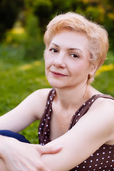 Retrato de mujer de mediana edad sonriendo en el parque —  Fotos de Stock