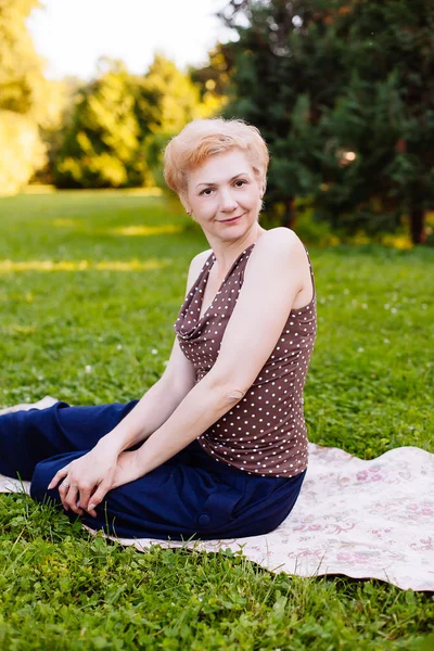 Retrato de mujer de mediana edad sonriendo en el parque — Foto de Stock