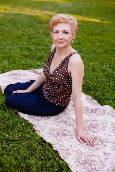 Portrait of middle aged woman smiling in the park — Stock Photo, Image