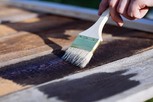 Pincel de pintura em uso de mesa de madeira para casa decorada. Casa Renova — Fotografia de Stock