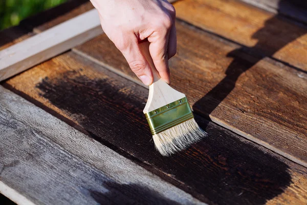 Pincel de pintura em uso de mesa de madeira para casa decorada. Casa Renova — Fotografia de Stock