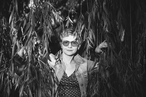 Portrait de femme d'âge moyen élégant souriant sur la nature bac — Photo