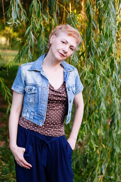 Portret van stijlvolle midden leeftijd vrouw die lacht op de natuur bac — Stockfoto