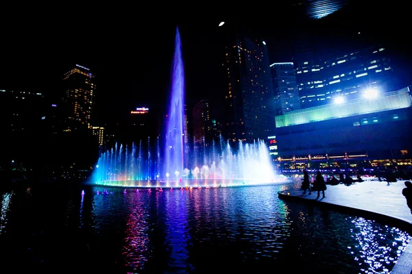 Podświetlane fontanny w nocy w panoramę miasta nowoczesnego, Kuala guzek — Zdjęcie stockowe
