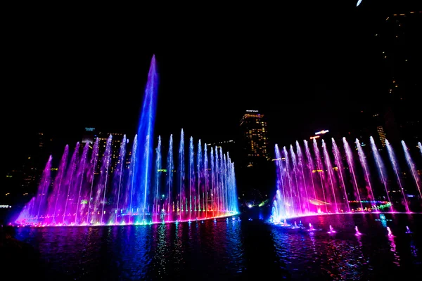 Svítící fontána v noci v moderní městské panorama, Kuala paušální — Stock fotografie
