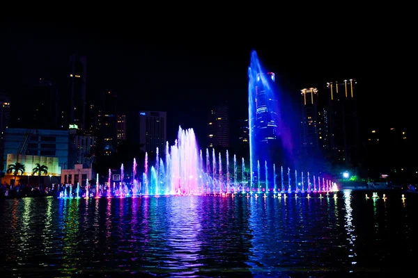 Fontaine éclairée la nuit dans les toits modernes de la ville, Kuala Lump — Photo