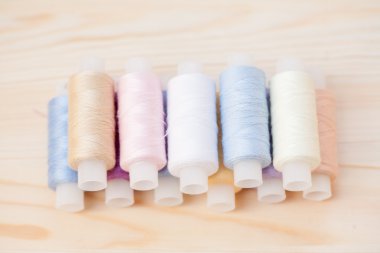 ahşap zemin üzerinde çok renkli dikiş ipliği