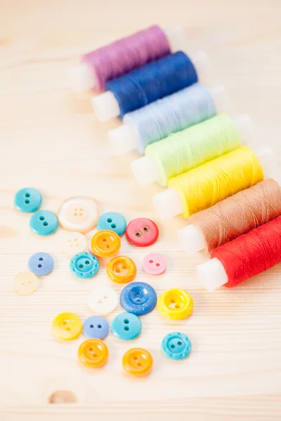 Threads and  buttons  on wooden table — Stock Photo, Image