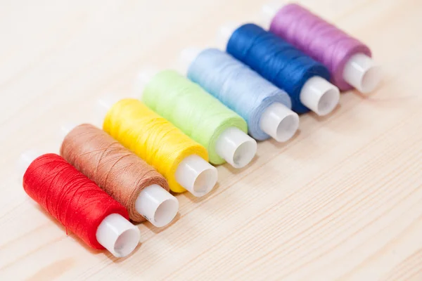 Multicolor threads op houten achtergrond — Stockfoto