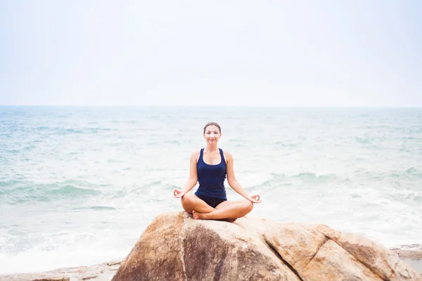 Woman Sitting in the Lotus Position on the Rock Above the Sea an — Stock Photo, Image