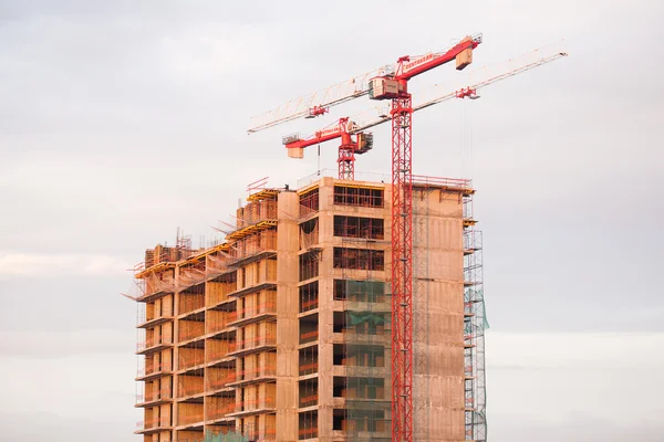 Kran och byggande hus under blå himmel — Stockfoto