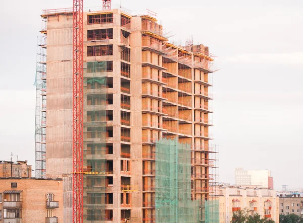 Kran och byggande hus under blå himmel — Stockfoto