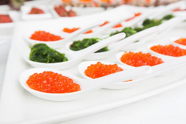 Caviar rojo de cerca en cucharas blancas en banquete — Foto de Stock