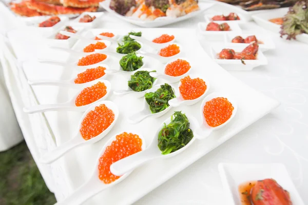 Caviar rojo de cerca en cucharas blancas en banquete — Foto de Stock