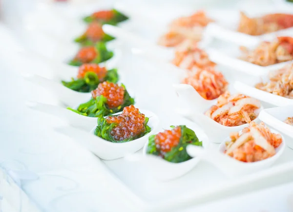 Caviar rojo de cerca en cucharas blancas en banquete — Foto de Stock